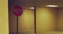 A stop sign reads backwards in a dingy, yellow hallway with many corridors.